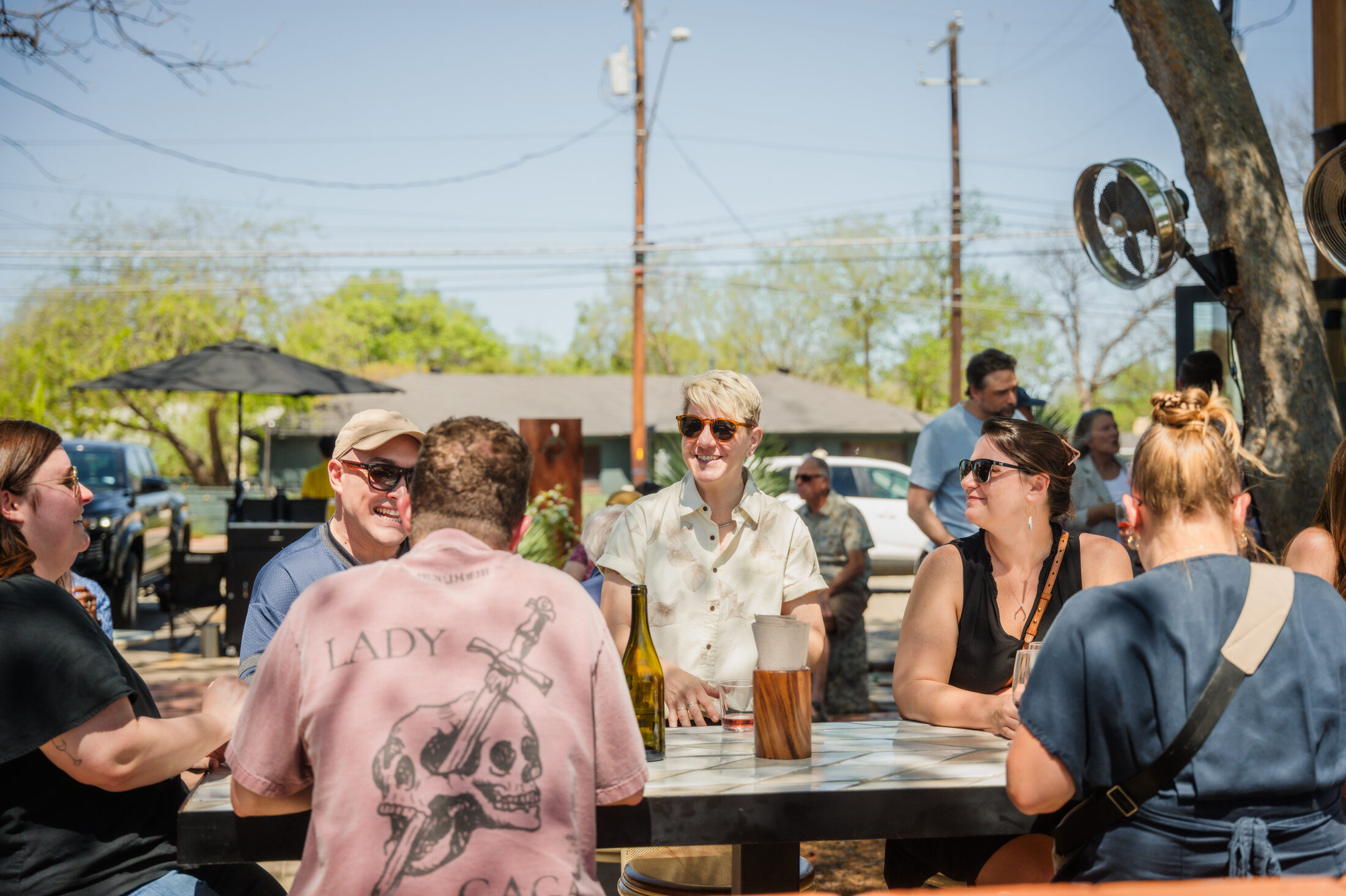 Rae Wilson pouring for guests at a patio table during the Spring 2026 club release