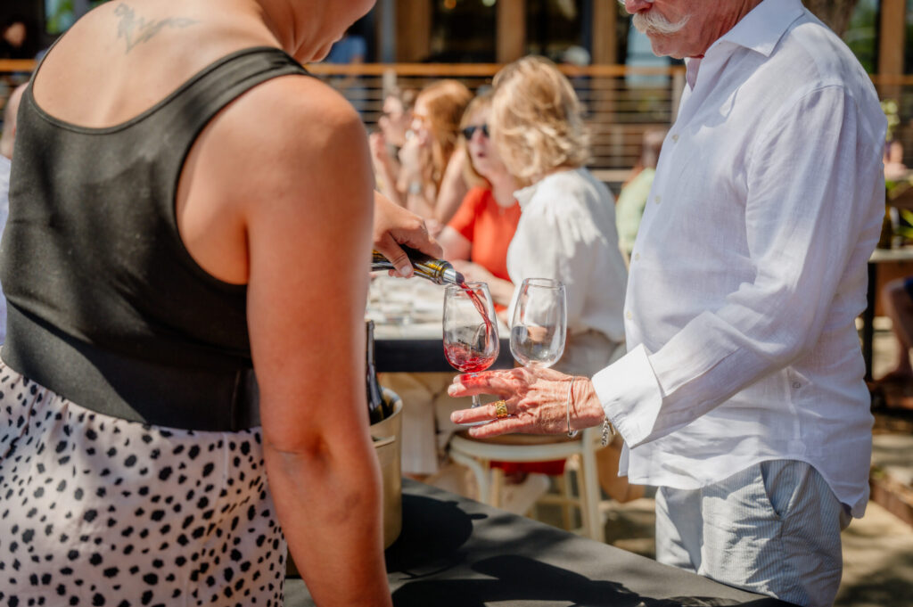 Pouring a glass of red for a guest at the Spring 2026 club release